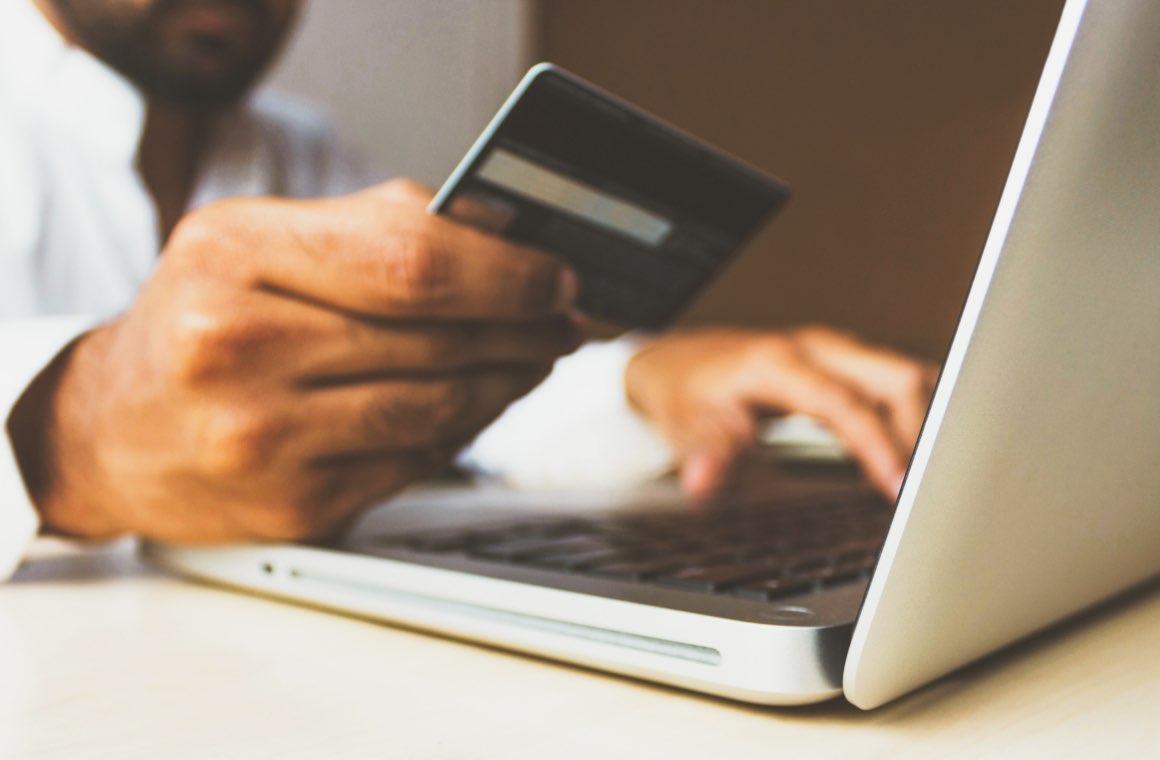 A person typing in credit card number on a laptop