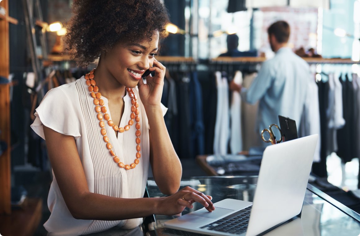 A woman working on a laptop at a clothing store