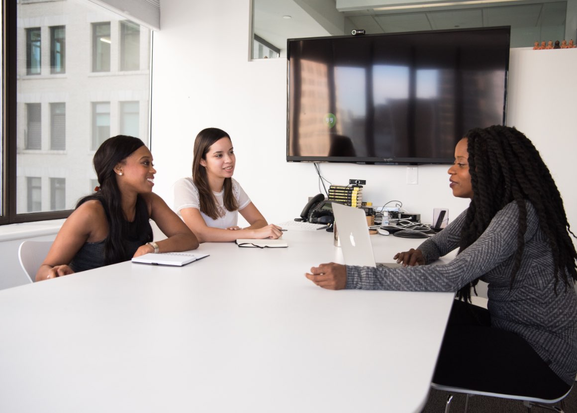 Three women in a conference room, meeting