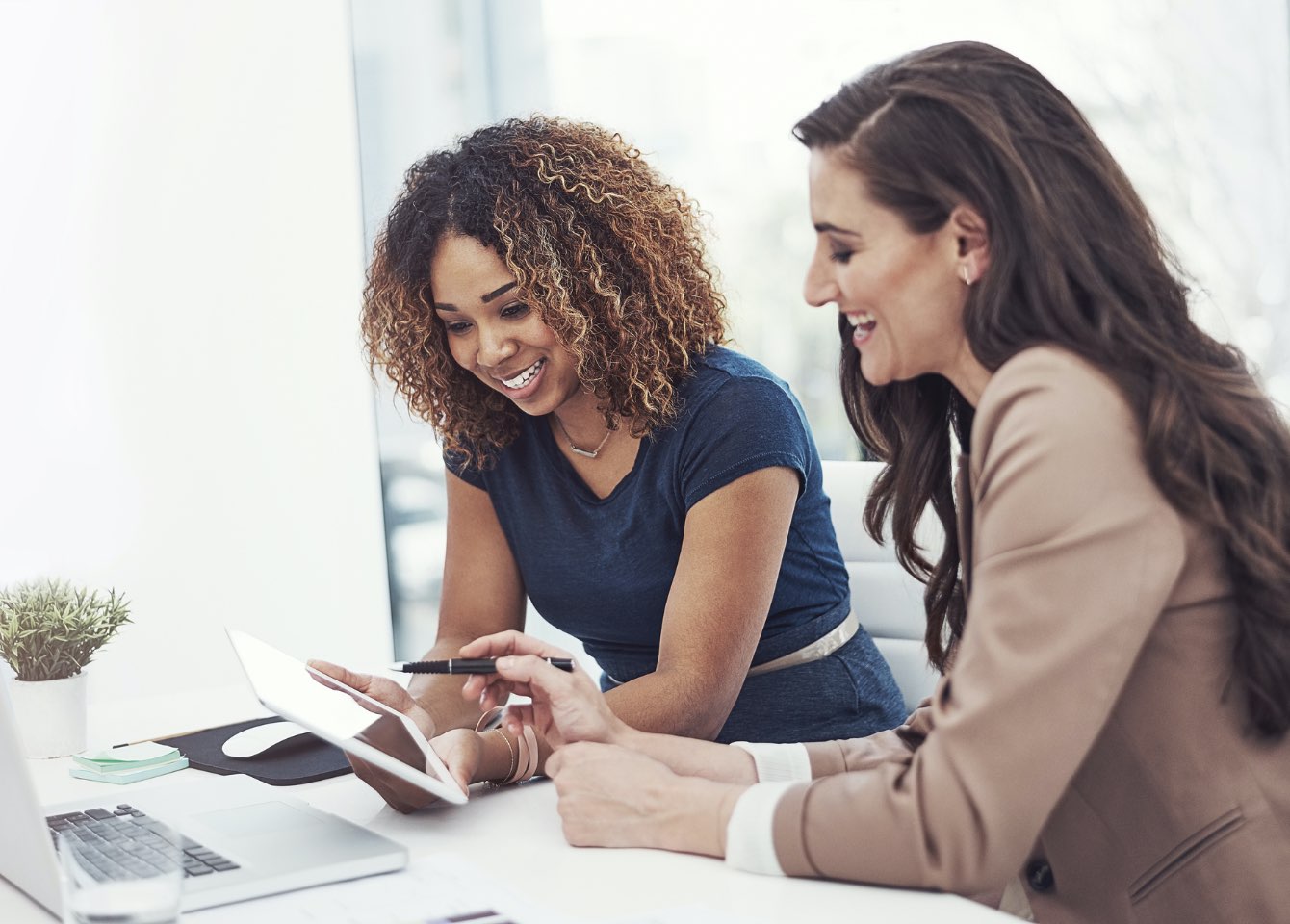 Two women working on a tablet