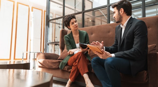 Two people meeting on a couch at an office