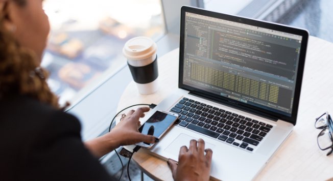 A close up of the laptop with a phone plugged in