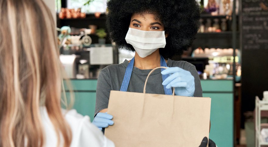 A store worker handing a bag to a customer