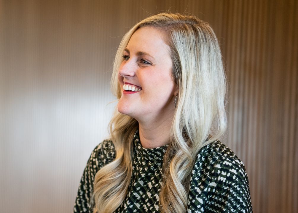 A female Heartland employee is smiling at something offscreen 