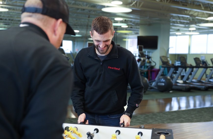 Two Heartland employees play foosball.