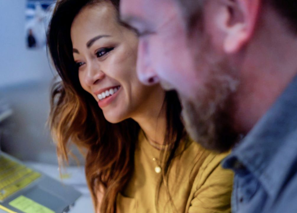 Two fintech sales employees smiling at something off screen