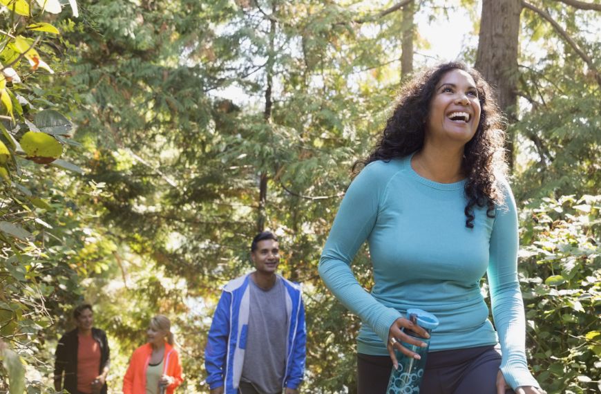 Four people smiling and hiking on a sales incentive trip