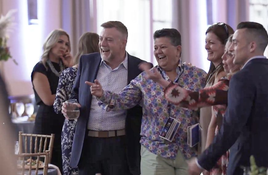 Large group of fintech sales employees smiling at a networking event