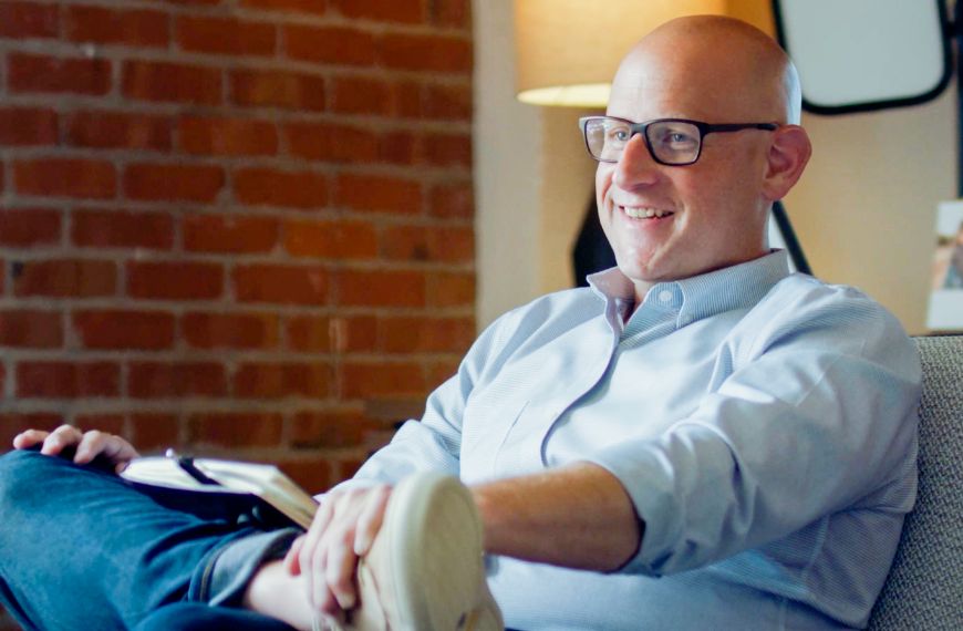 A Heartland employee sits in a conference room with their legs crossed.