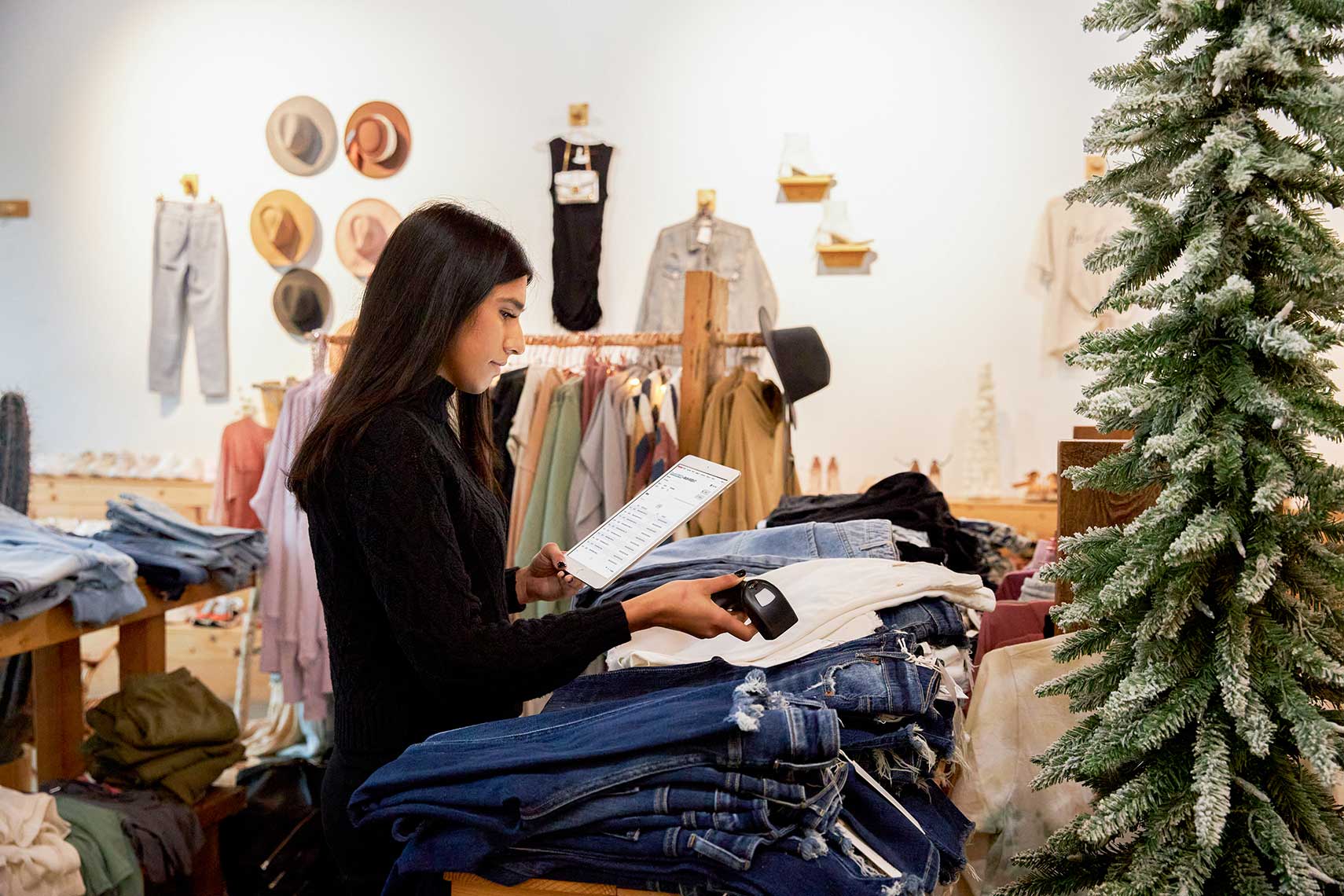 A woman scanning jeans on the counter. 