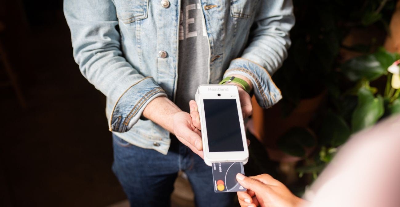 beginners guide to PCI DSS compliance - person inserting a credit card into a reader