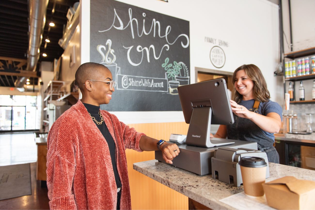 A woman paying at a coffee shop with her watch contact free.