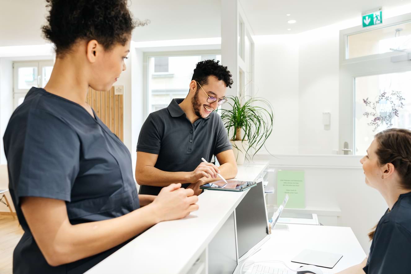 man and woman in scrubs talking at a medical check in counter