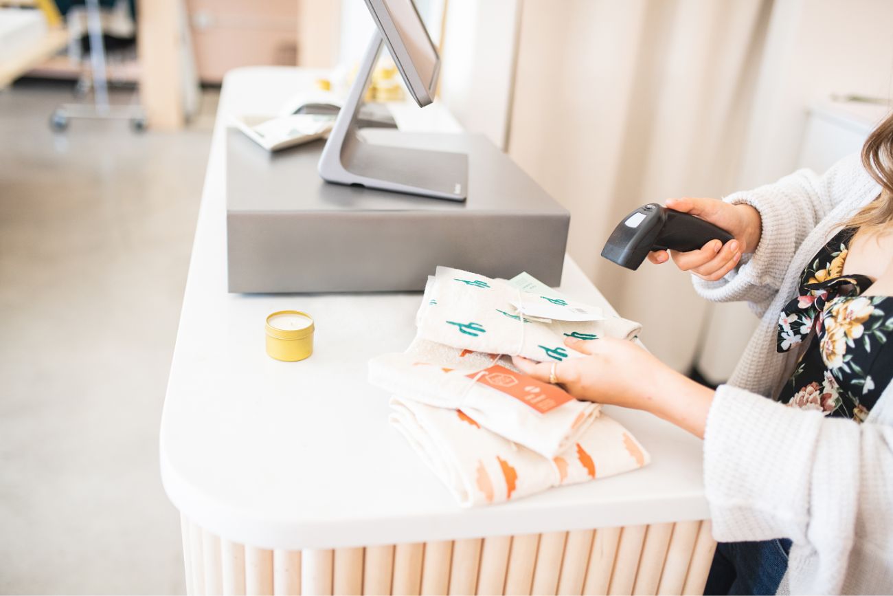 A woman employee scanning small products in a store.