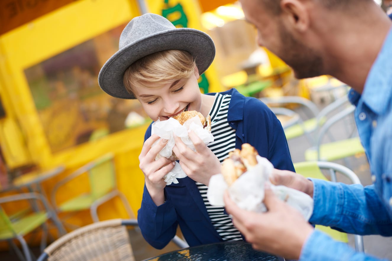 man and woman eating food outside