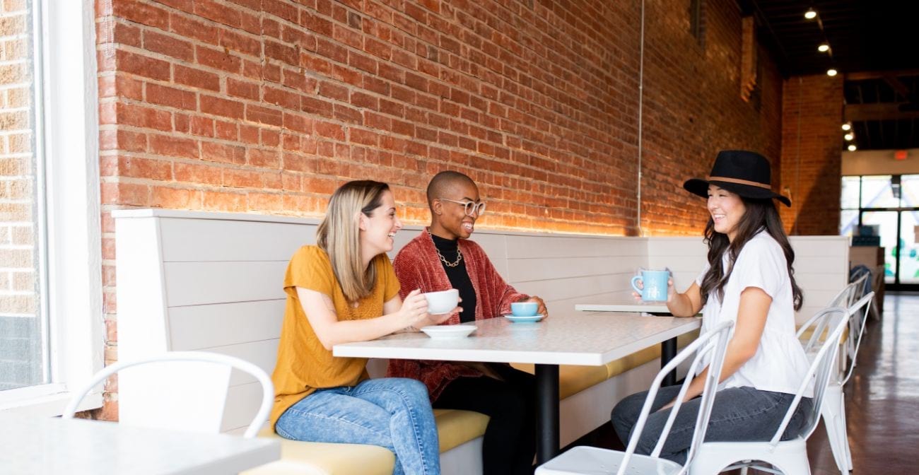 How To Pick The Right POS System for Your Coffee Shop - 3 people at a table with coffee