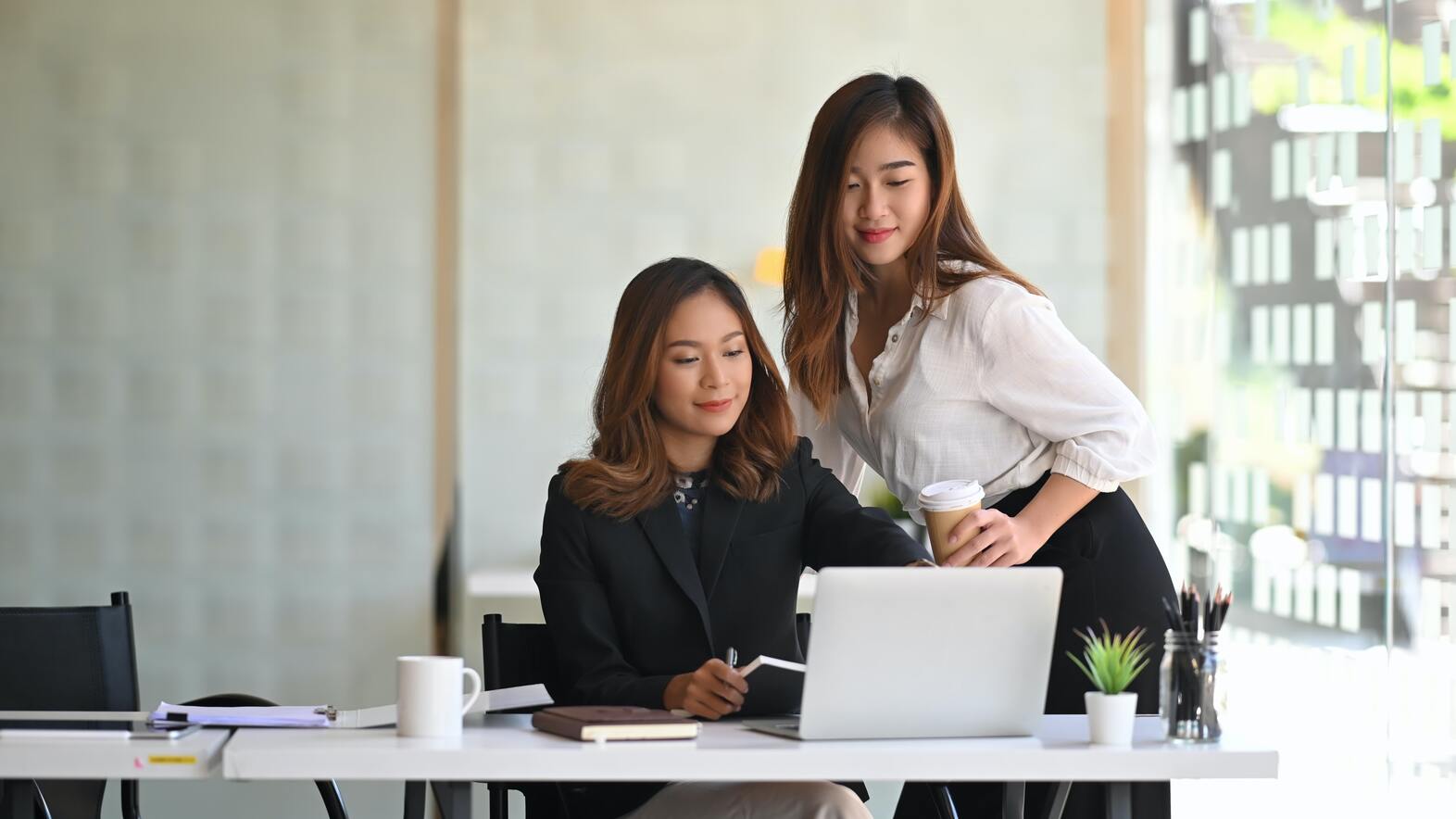 two woman looking at a computer screen