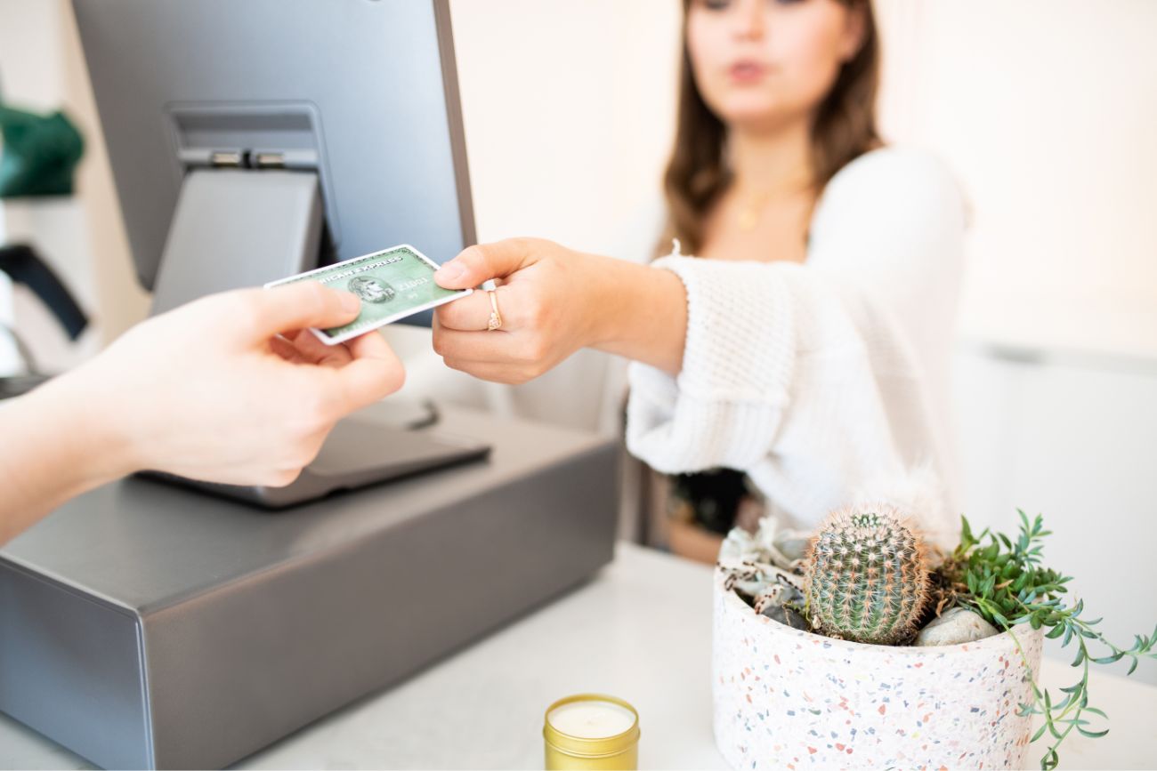 A woman employee handing a customer their credit card back.