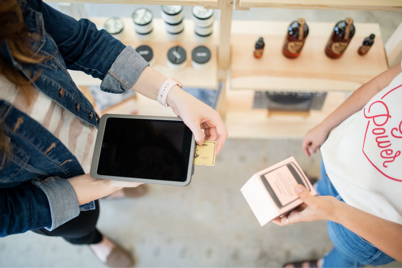 A woman paying with a credit card in a handheld mobile device.