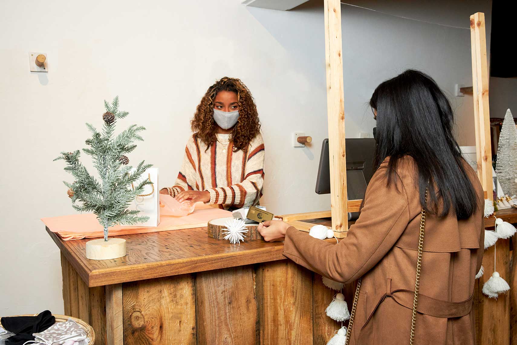 A woman checking out with a store employee. 