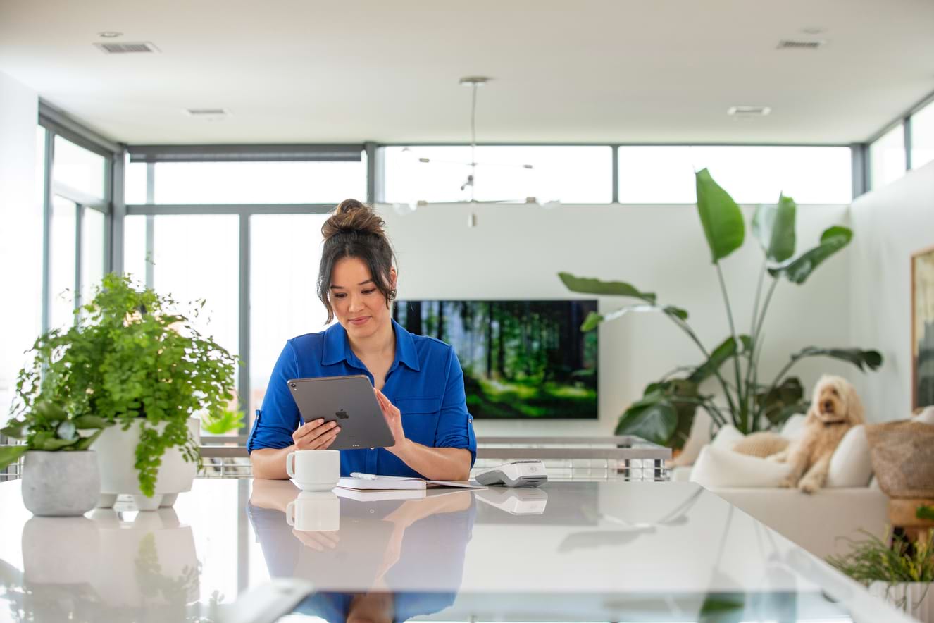 woman at a table looking at a tablet