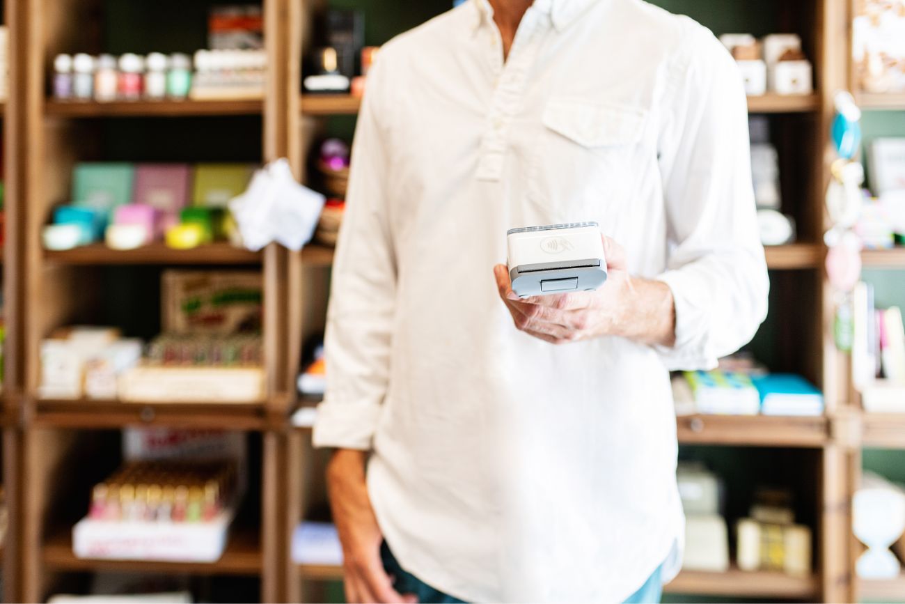 An employee holing a mobile POS device.