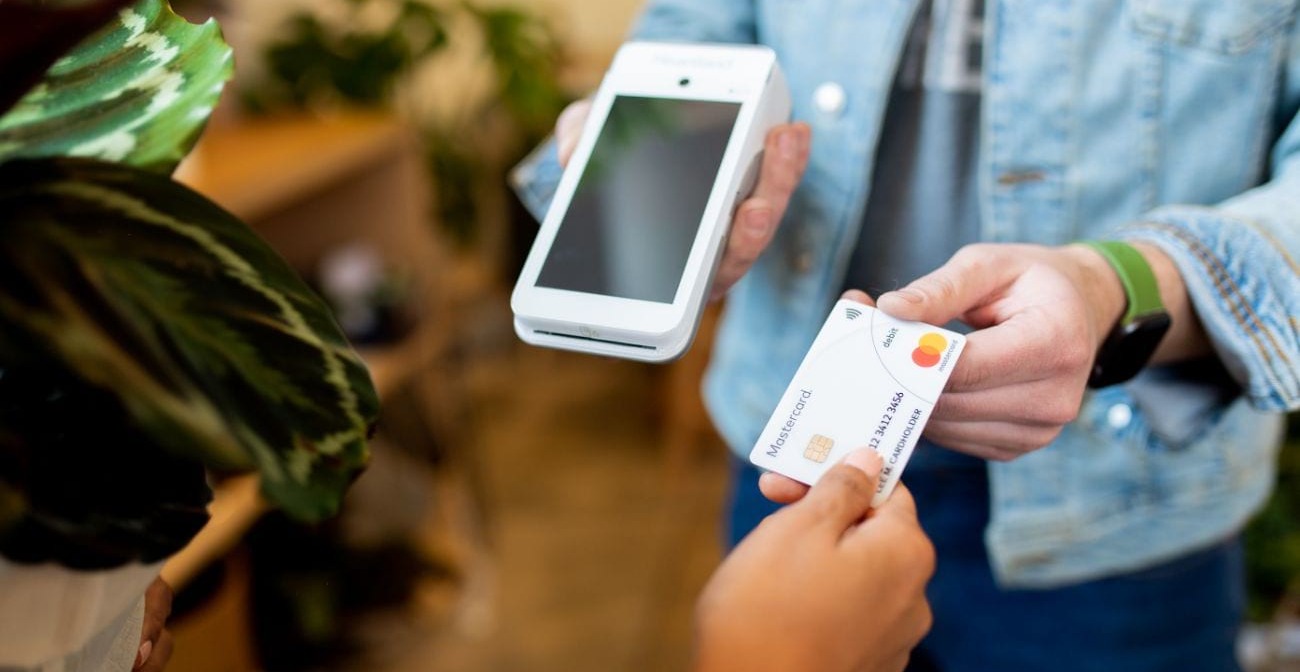 What's Next After EMV Chip Cards?  - person handing EMV credit card to merchant