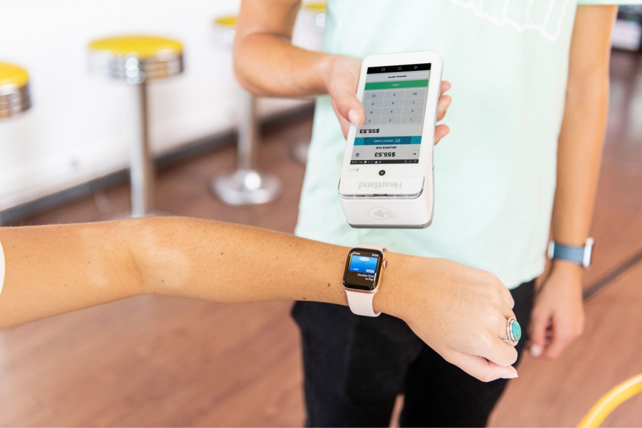 A customer paying with their smart watch on a mobile POS system.