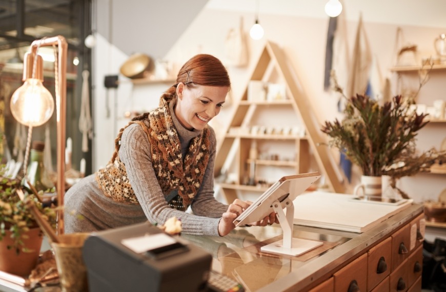 A woman using a POS at a counter in a boutique