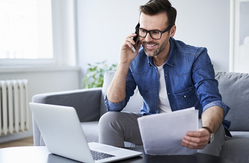 A man holding papers and talking on his phone