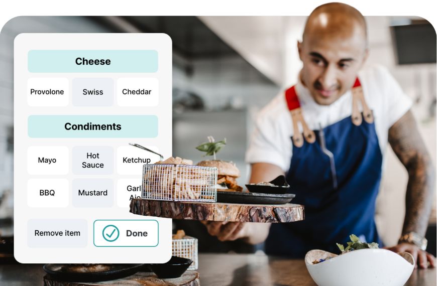 Male chef handing over a burger in a restaurant next to a Heartland Mobile POS screen showing burger customization options
