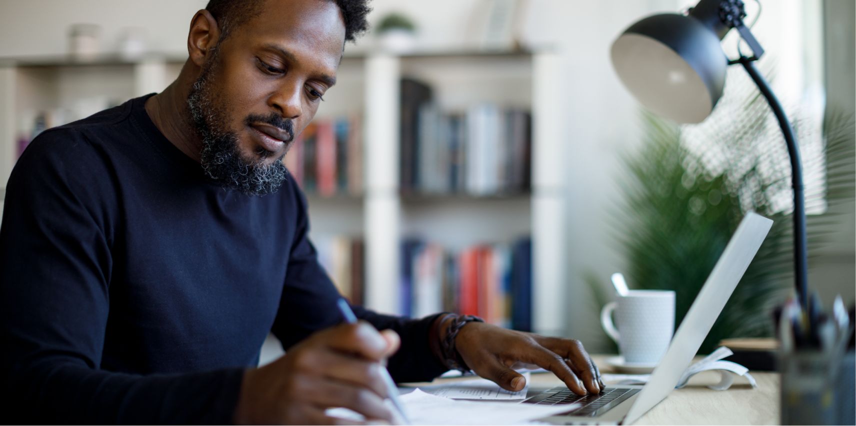 A man writing notes at his desk