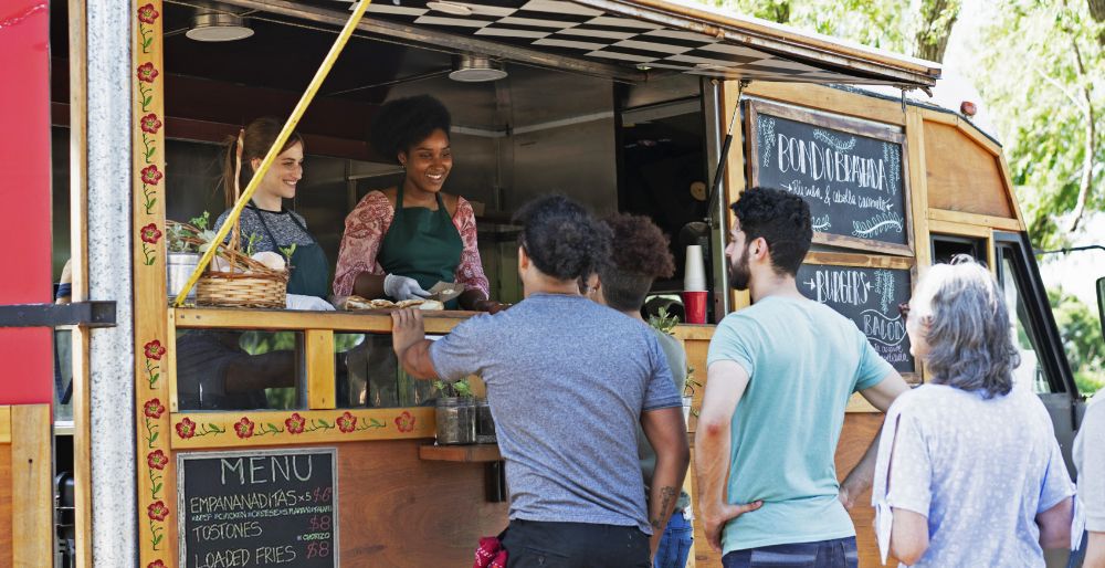 A line of customers waiting to order at a food truck.