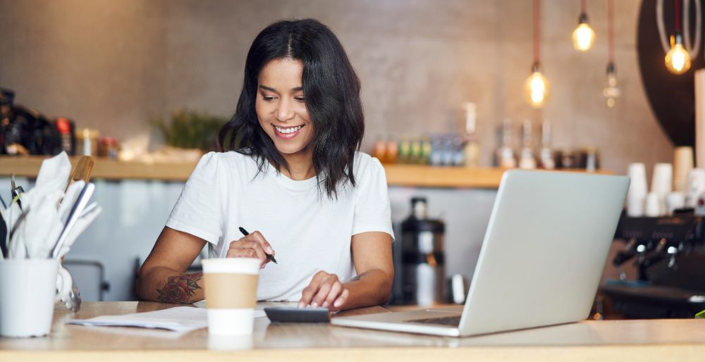 One woman doing calculations at a cafe with her laptop
