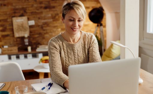 A woman smiling while using her laptop