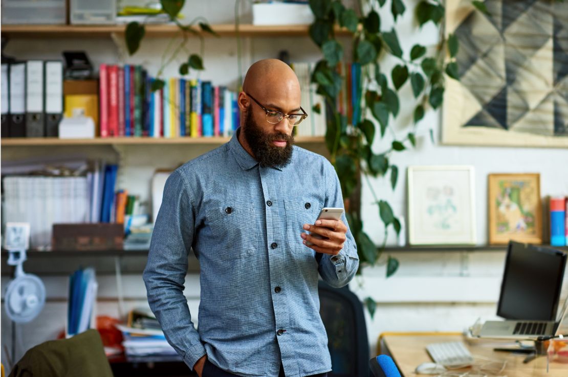 A man looking nervously at his phone in a small business' back office