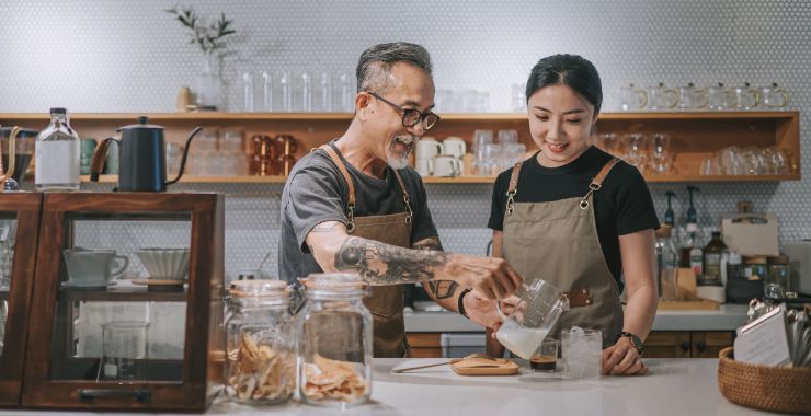 Coffee shop manager pouring a drink for one of his team members