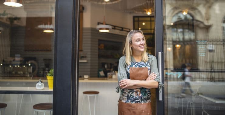 Entrepreneur smiles looking outside of her small business