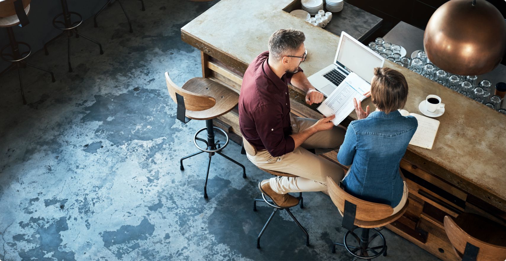 Small business owners review crisis management plan on paper and laptop