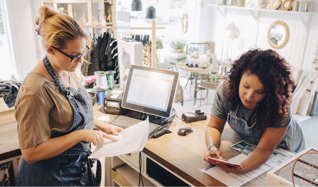 Retail business owner and manager review crisis management plan on paper and tablet