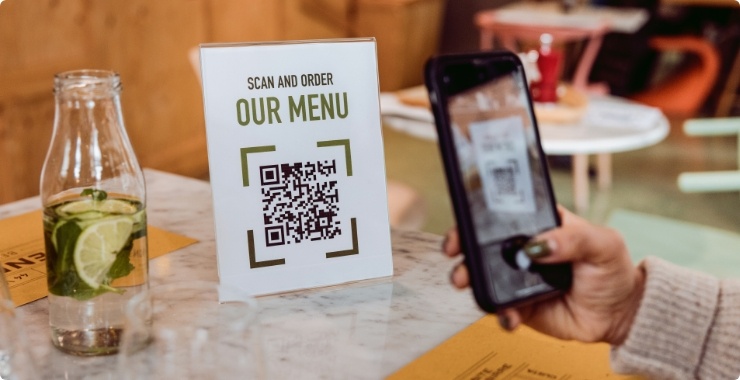 Person using mobile phone to scan an QR code in a restaurant