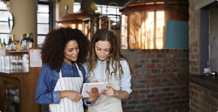 Two restaurant owners looking at options on a tablet
