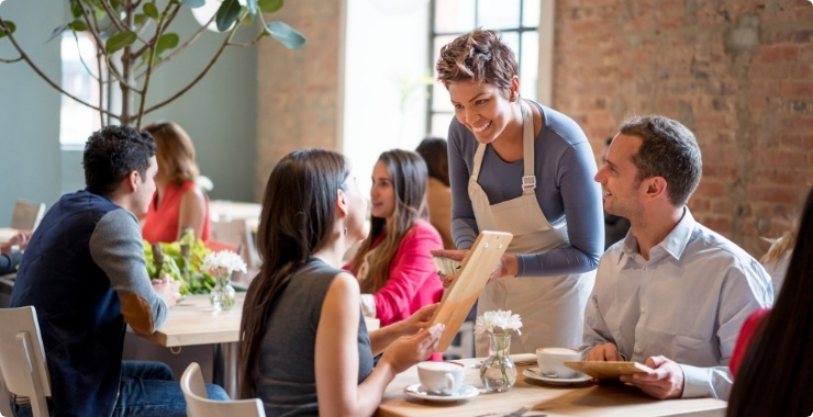 Restaurant employee working with customers to place their order in a cafe