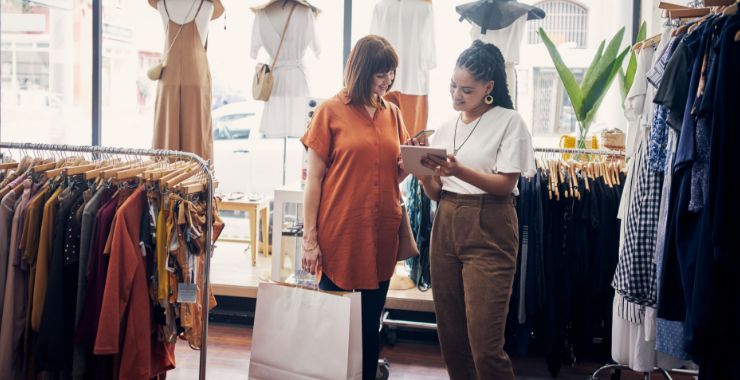 Saleswoman using a mobile POS to check out a customer in a clothing store