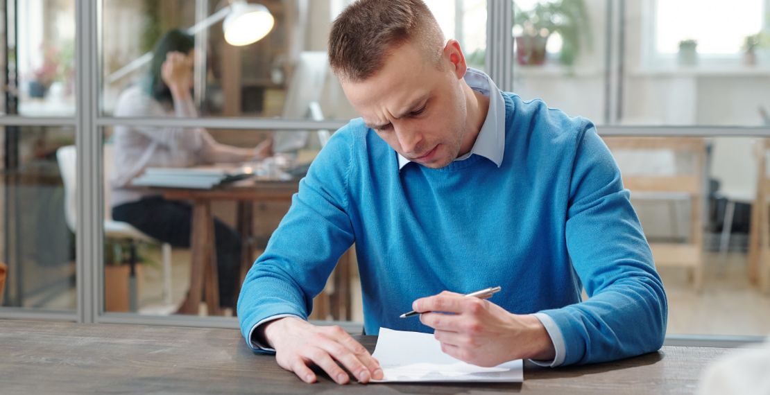 Person in blue shirt studies merchant services provider contract.