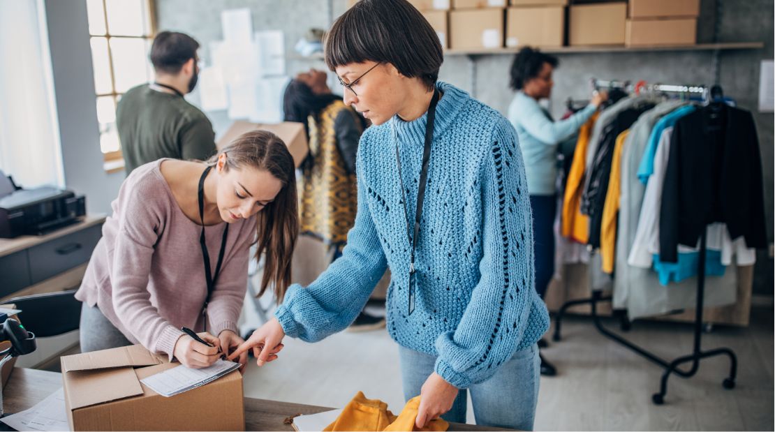 Two women packaging up an order in a clothing showroom
