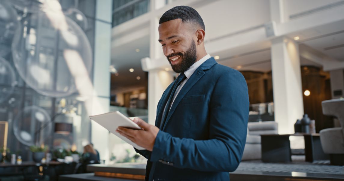 Hotel employee looking down at a tablet hotel POS