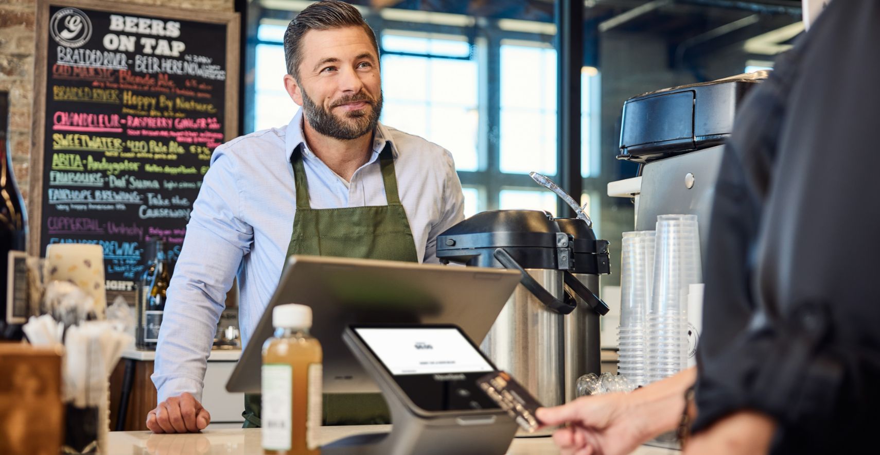 Cafe business owner using Heartland Point of Sale System