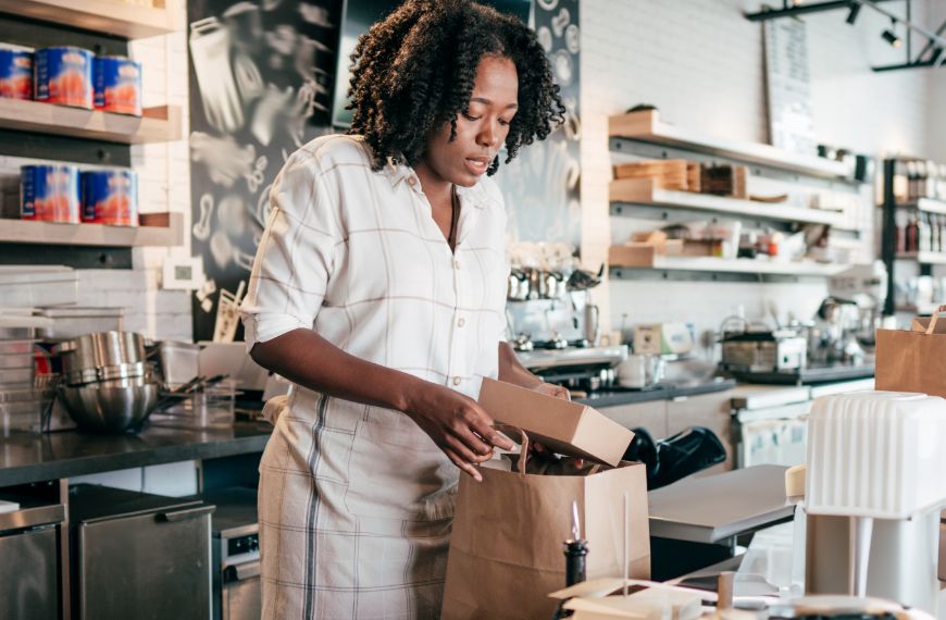 Cafe employee boxing a holiday to-go order