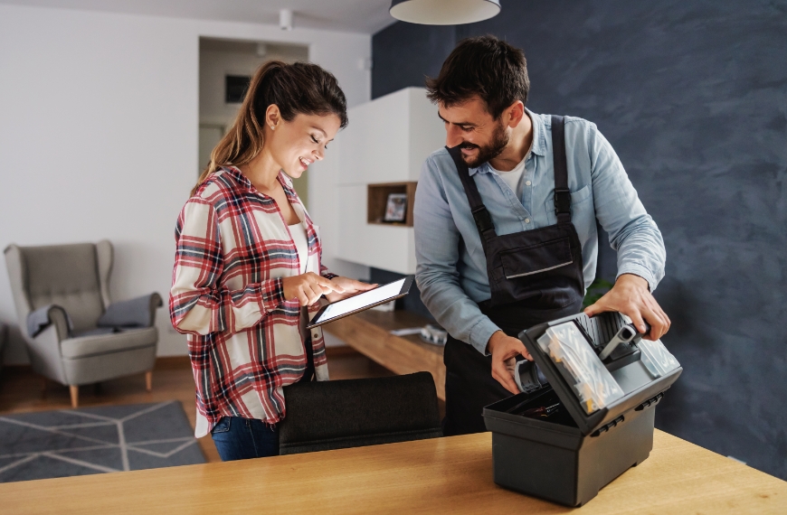 A home services employee packing his toolbox while a customer pays with a mobile terminal